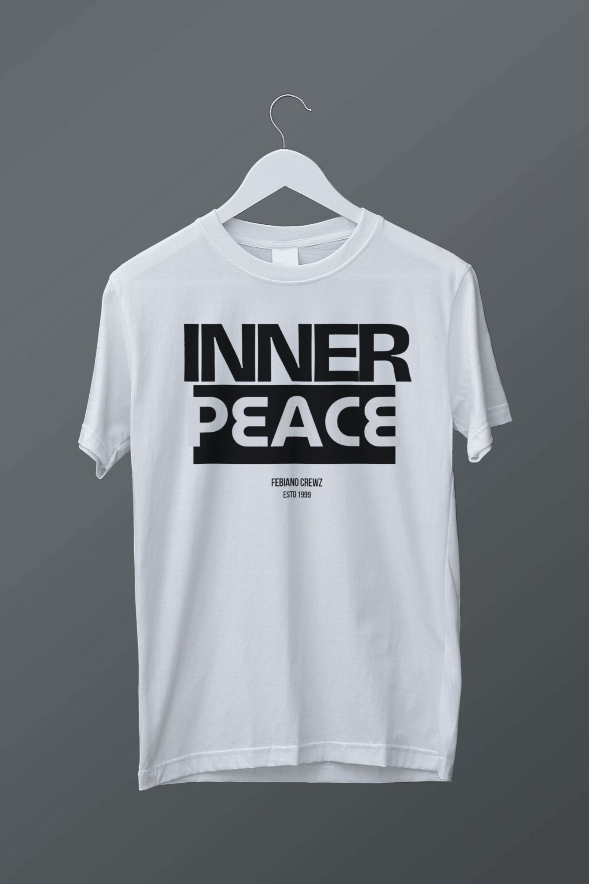 White t-shirt with 'INNER PEACE' text on a hanger against a dark background