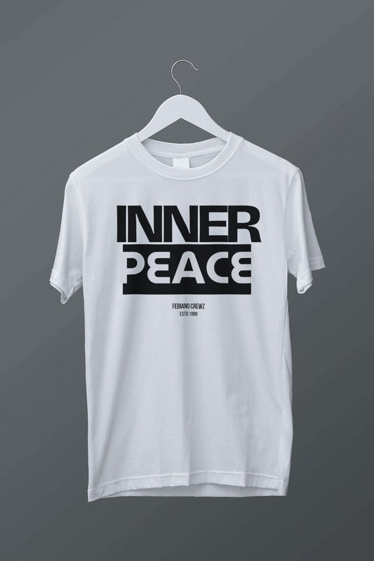 White t-shirt with 'INNER PEACE' text on a hanger against a dark background